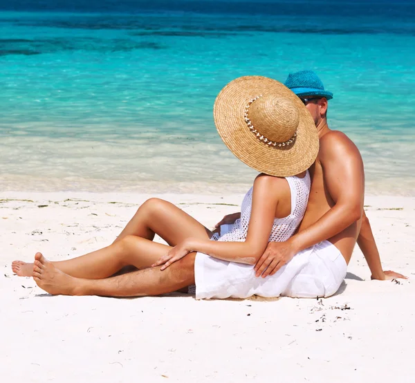 Coppia in bianco rilassarsi su una spiaggia alle Maldive — Foto Stock