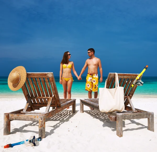 Casal em amarelo em uma praia em Maldivas — Fotografia de Stock