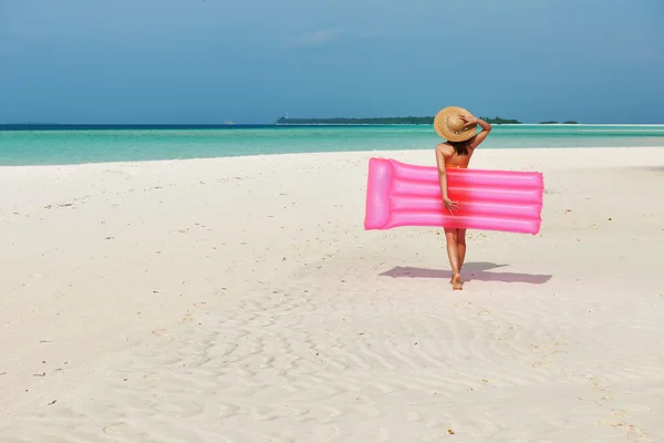 Femme avec radeau gonflable rose à la plage — Photo
