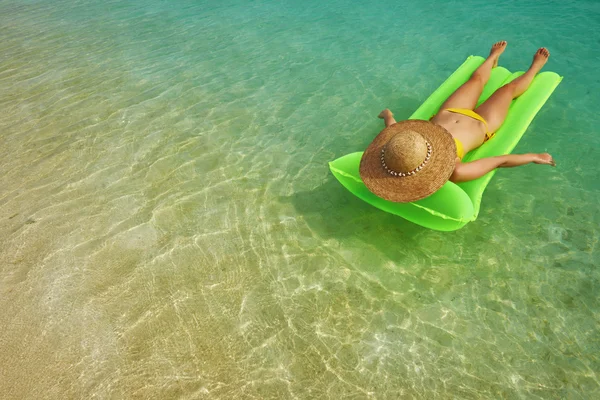 Donna che si rilassa sul materasso gonfiabile vicino alla spiaggia — Foto Stock