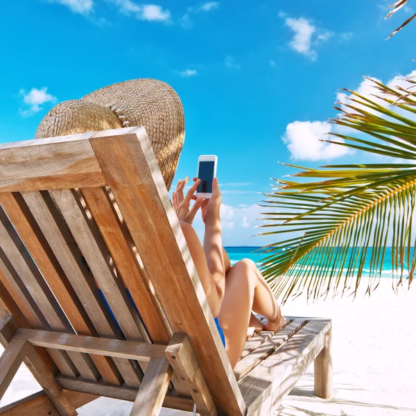 Молодая женщина с планшетным ПК на пляже — стоковое фото
