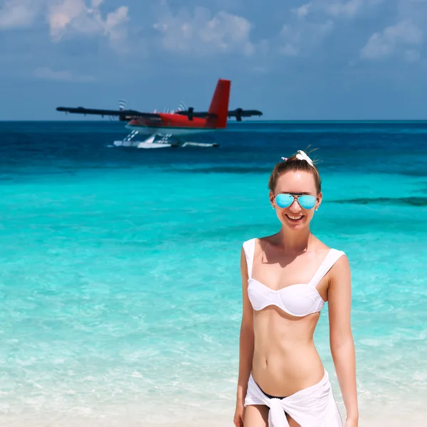 Kvinna på stranden. sjöflygplan på bakgrunden. — Stockfoto