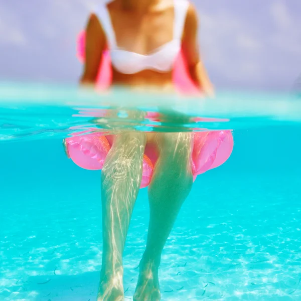 Donna che si rilassa sul materasso gonfiabile, vista da sott'acqua — Foto Stock