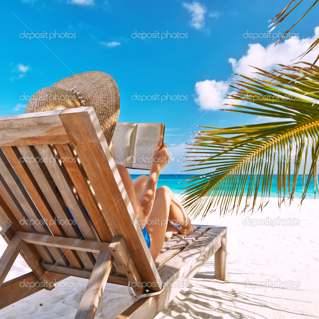 Young woman reading a book at beach