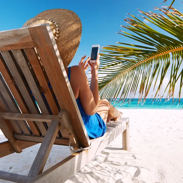 Mujer joven con tablet PC en la playa — Foto de Stock