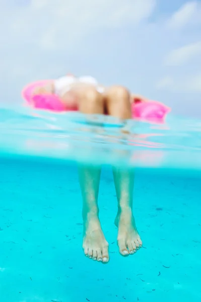 Vrouw ontspannen op opblaasbare matras, uitzicht vanaf onderwater — Stockfoto