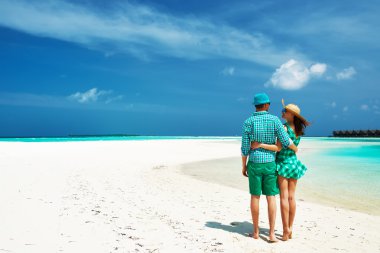 Couple in green on a beach at Maldives clipart
