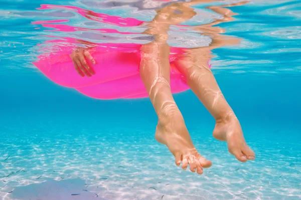 Женщина отдыхает на надувном матрасе, вид из-под воды — стоковое фото