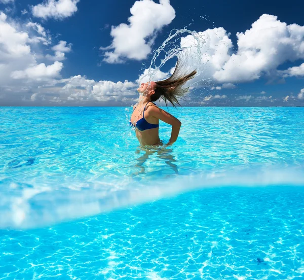 Mulher salpicando água com cabelo no oceano — Fotografia de Stock