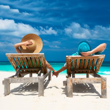 Couple in green on a beach at Maldives clipart