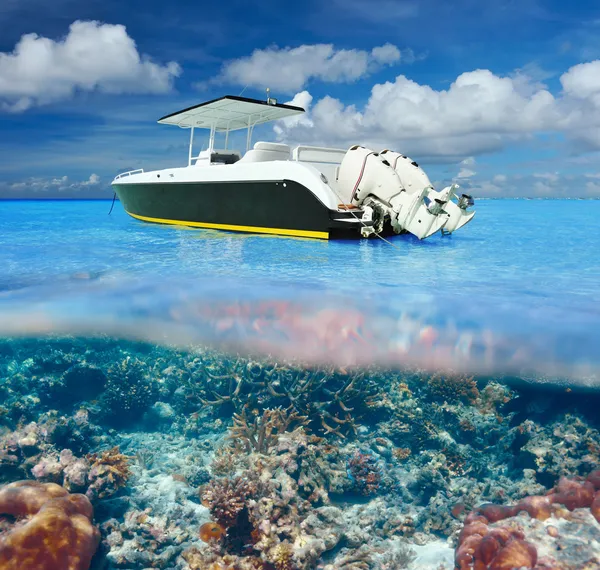 Beach and motor boat with coral reef underwater view