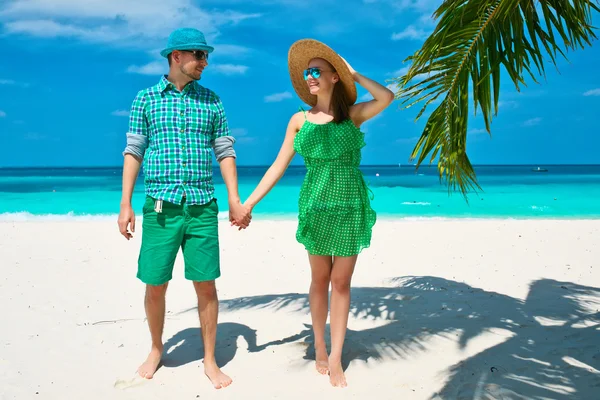 Пара в зеленом на пляже на Мальдивах — стоковое фото