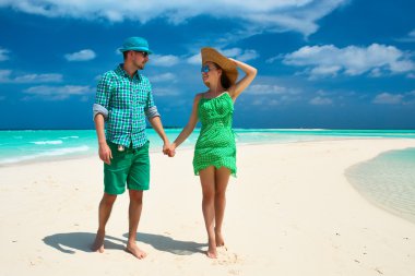 Couple in green on a beach at Maldives clipart
