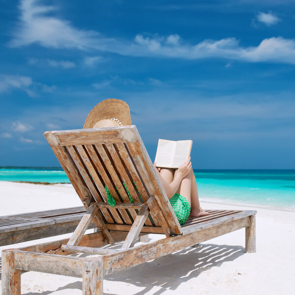 Young woman reading a book at beach