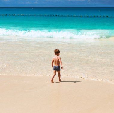 Two year old boy playing on beach