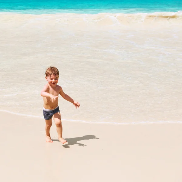 Två år gammal pojke leker på stranden — Stockfoto