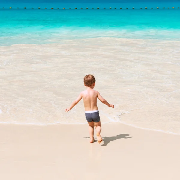 Двухлетний мальчик играет на пляже — стоковое фото
