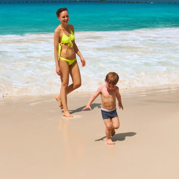 Moeder en twee jaar oude jongen spelen op strand — Stockfoto