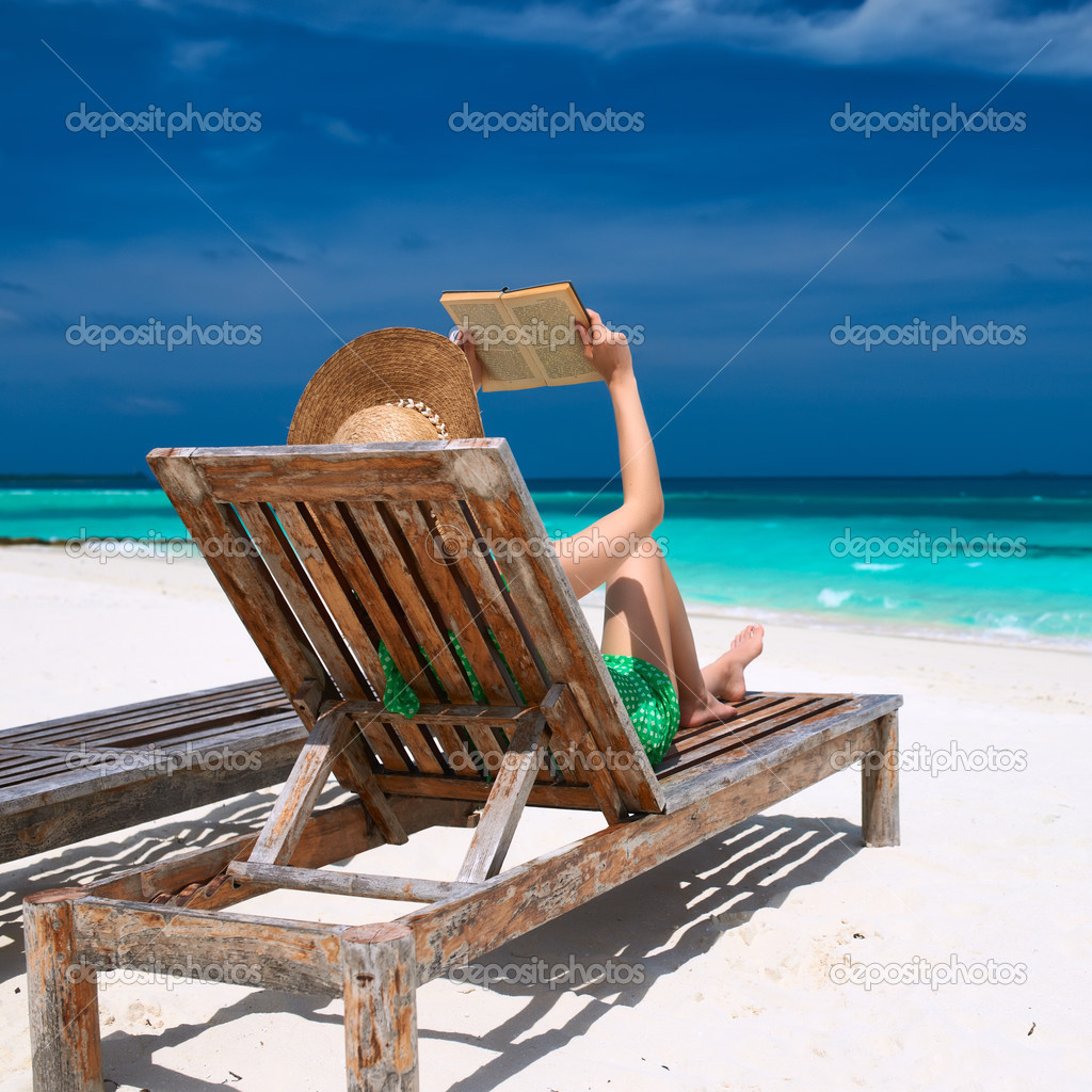 woman reading a book at beach