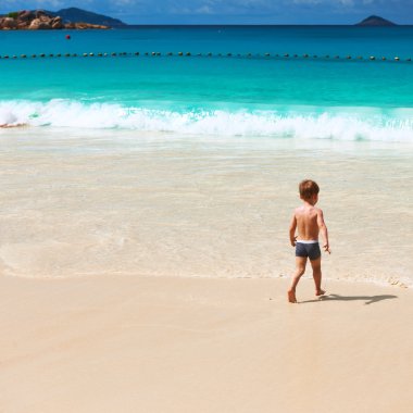 Two year old boy playing on beach