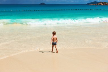 Two year old boy playing on beach