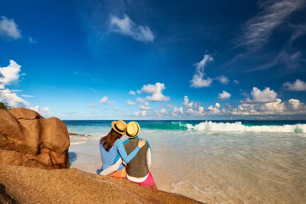 Couple at tropical beach wearing rash guard — Stock Photo, Image