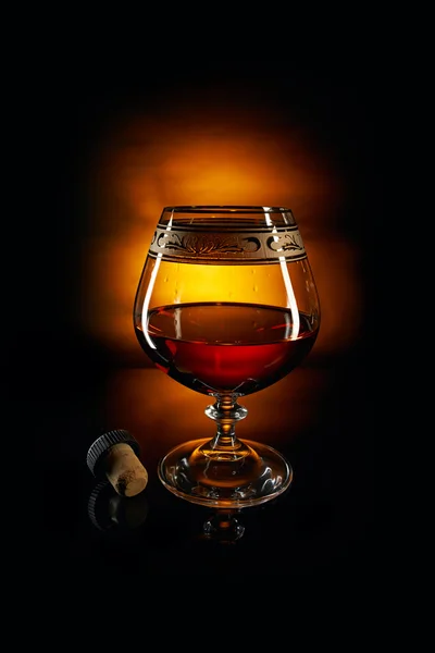 Glass of brandy and cork — Stock Photo, Image