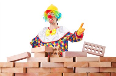 Bad construction concept with clown laying bricks clipart
