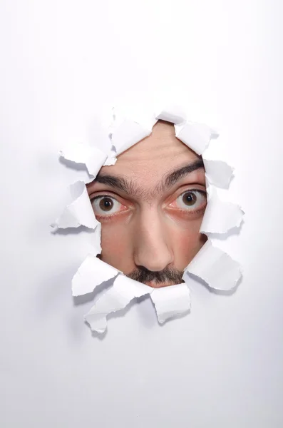 Male face through the hole in paper — Stock Photo, Image