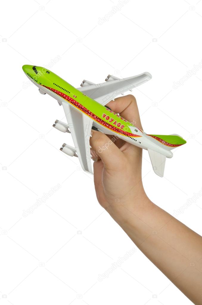 Hand holding toy airplane isolated on white