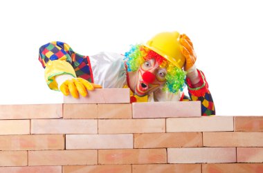 Bad construction concept with clown laying bricks clipart