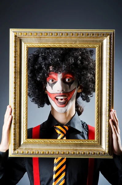 Clown with picture frames in studio — Stock Photo, Image