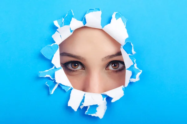 Cara femenina a través del agujero en papel —  Fotos de Stock