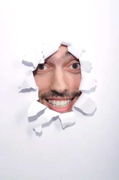 Man gezicht door het gat in papier — Stockfoto