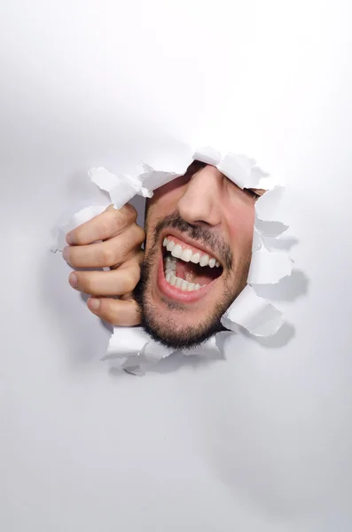 Male face through the hole in paper — Stock Photo, Image