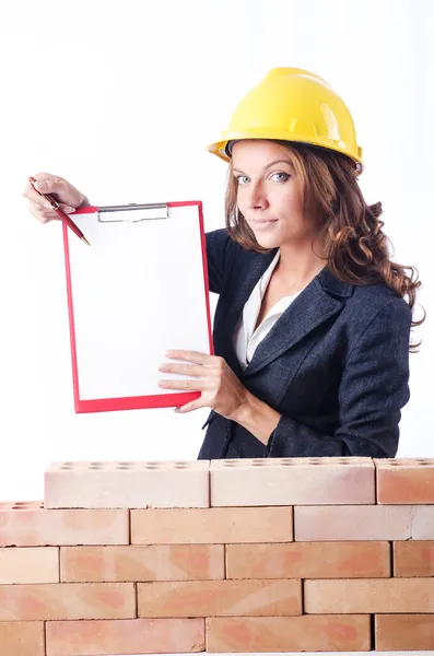 Kobieta konstruktora i ceglane ściany — Zdjęcie stockowe