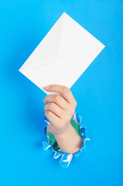 Ruka držící papírové obálky z díry — Stock fotografie