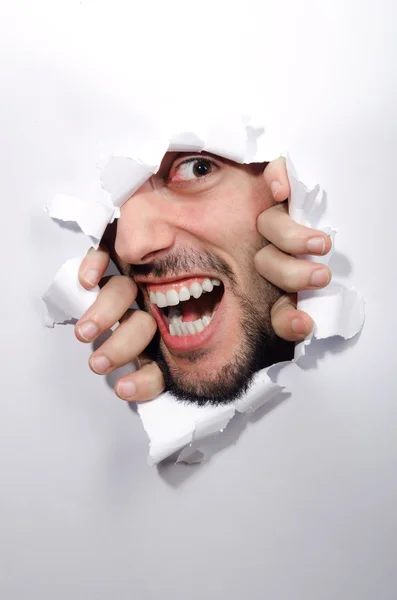 Male face through the hole in paper — Stock Photo, Image