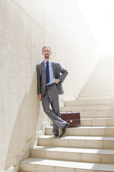 Empresário com escada no conceito de negócio — Fotografia de Stock