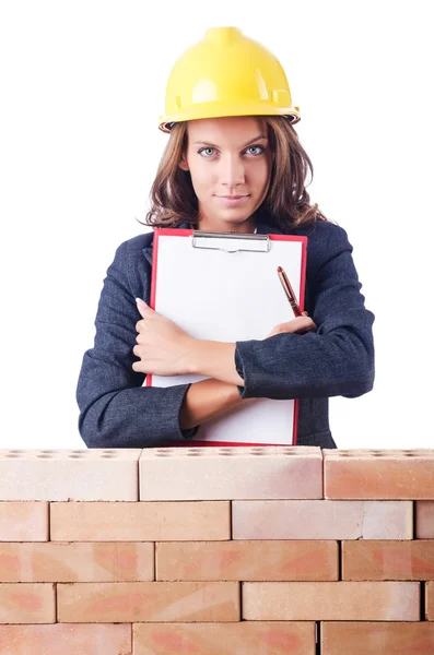 Vrouw bouwer en bakstenen muur — Stockfoto