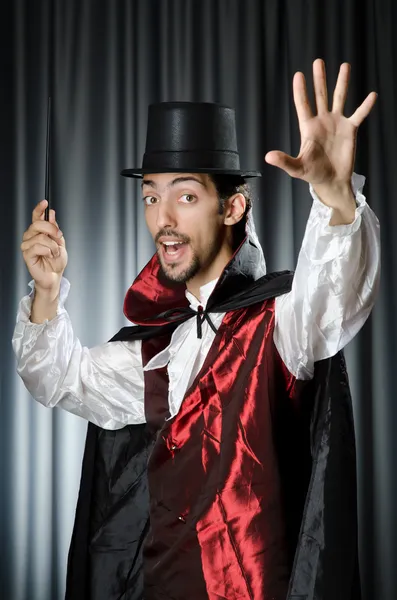Kouzelník dělá triky na bílém pozadí — Stock fotografie