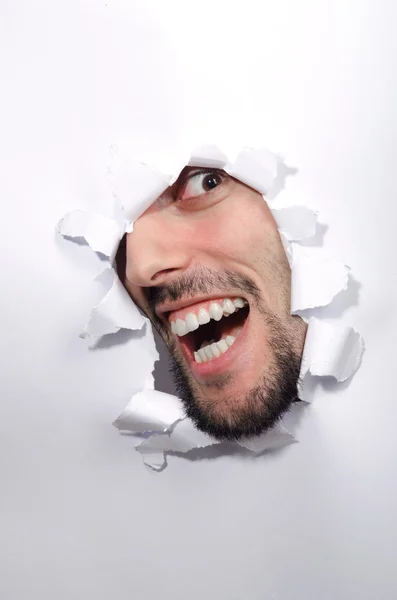 Male face through the hole in paper — Stock Photo, Image