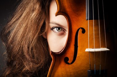Woman with violin in dark room