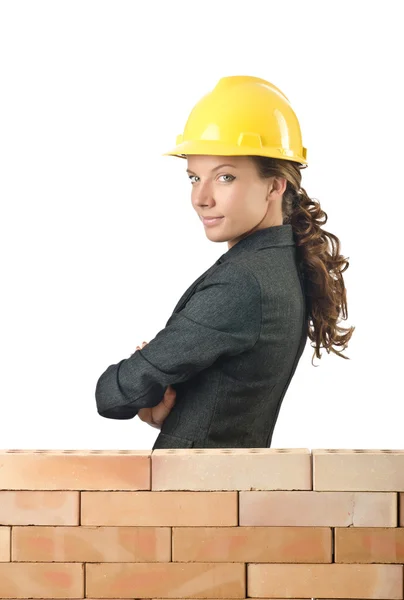 Jovem construtor feminino perto da parede de tijolo — Fotografia de Stock