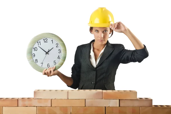 Femme constructeur et horloge sur blanc — Photo