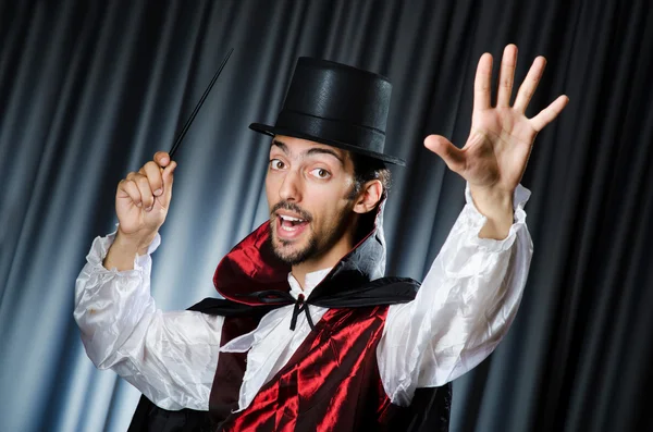 Kouzelník dělá triky v temné místnosti — Stock fotografie