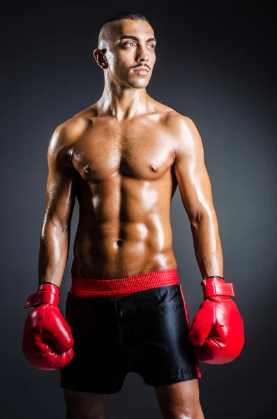 Boxeador con guantes rojos en habitación oscura —  Fotos de Stock