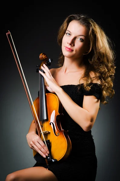 Woman with violin in dark room — Stok fotoğraf