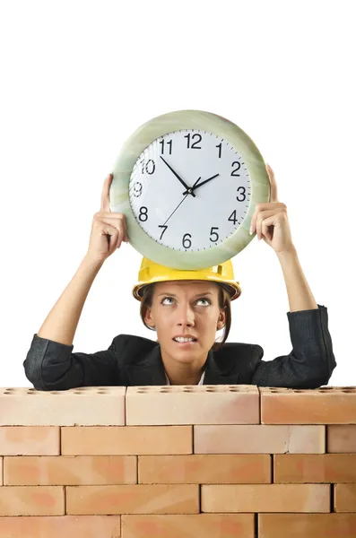 Female builder and clock on white — Stock Photo, Image