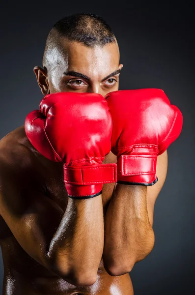 Boxeador con guantes rojos en habitación oscura — Foto de Stock